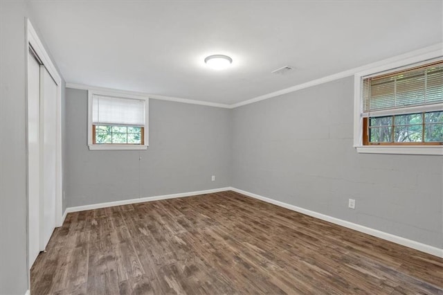 spare room with hardwood / wood-style floors, plenty of natural light, and crown molding