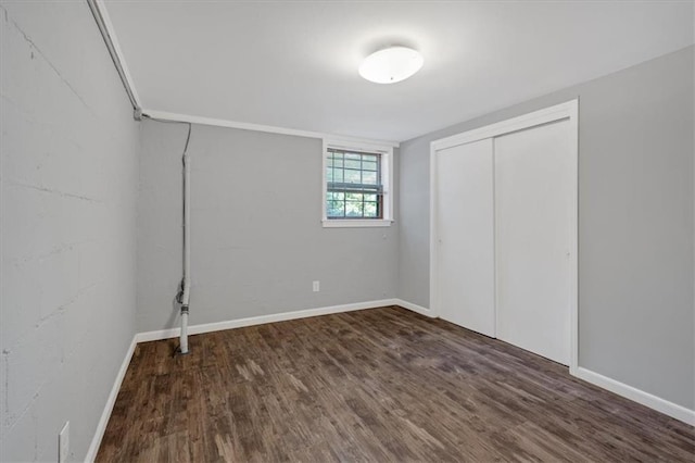 unfurnished bedroom featuring a closet and dark wood-type flooring