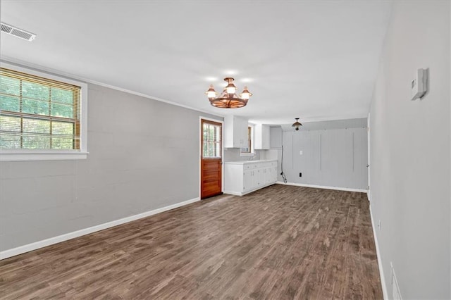 unfurnished living room with hardwood / wood-style flooring and a notable chandelier