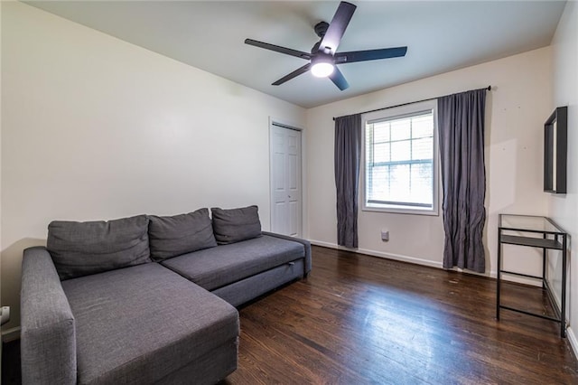 living room featuring ceiling fan and dark wood-type flooring