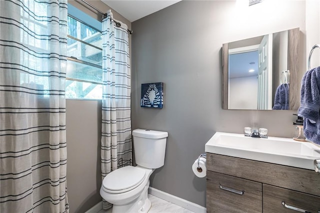 bathroom with vanity, toilet, and a wealth of natural light