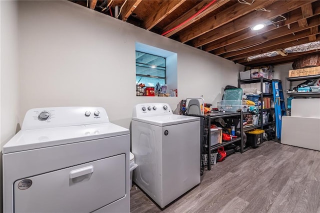 clothes washing area featuring light hardwood / wood-style floors and independent washer and dryer