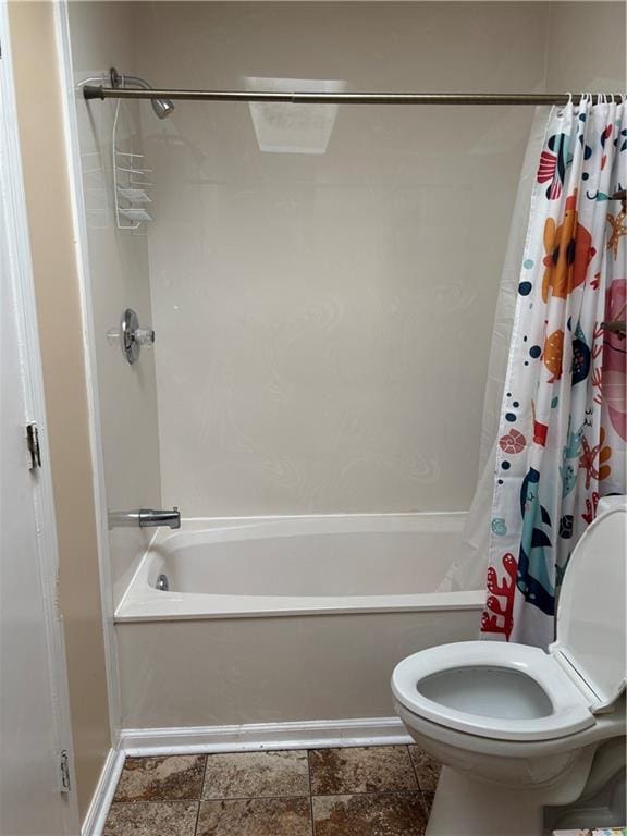 full bathroom featuring toilet and shower / bath combo with shower curtain