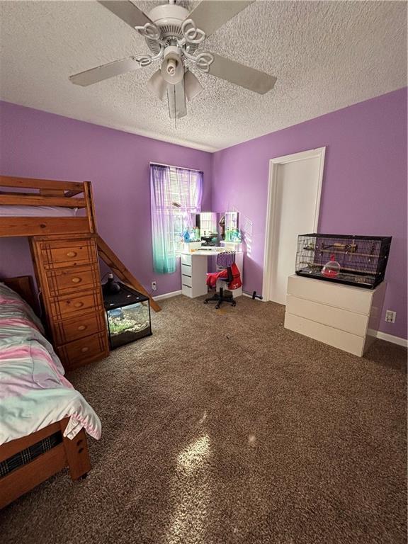 carpeted bedroom featuring a textured ceiling and ceiling fan