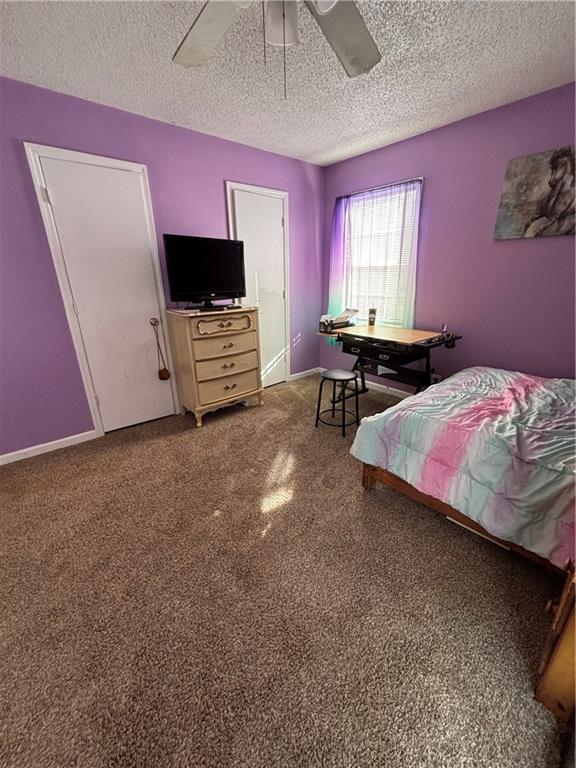 bedroom with a ceiling fan, a textured ceiling, and baseboards