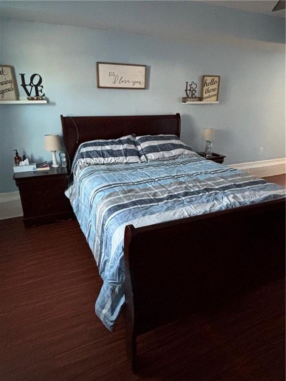 bedroom with baseboards and wood finished floors