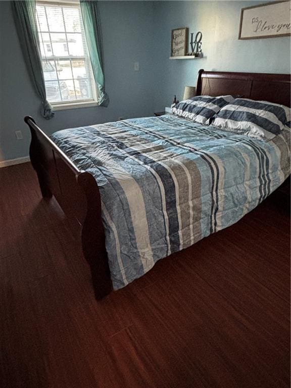 bedroom with wood finished floors and baseboards