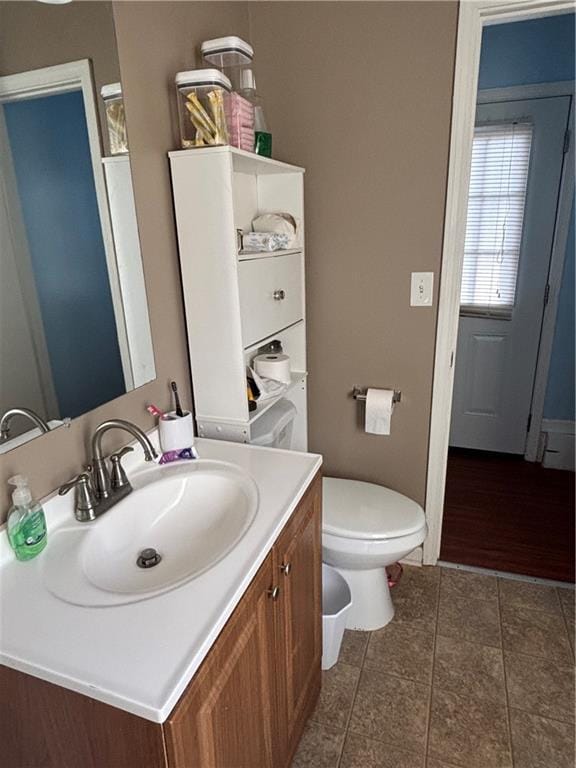 bathroom with tile patterned flooring, vanity, and toilet