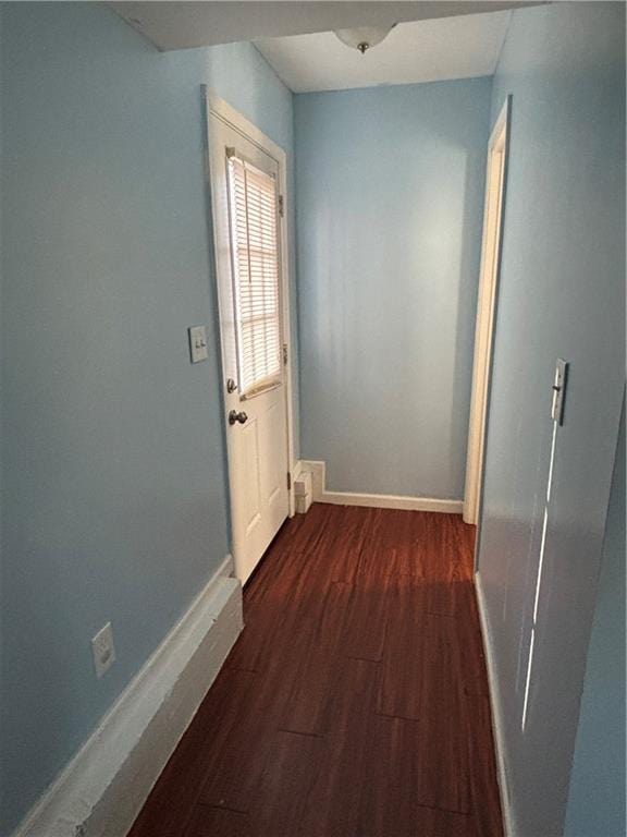 hall with dark wood finished floors and baseboards