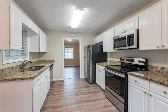 kitchen featuring sink, white cabinets, stainless steel appliances, and a textured ceiling