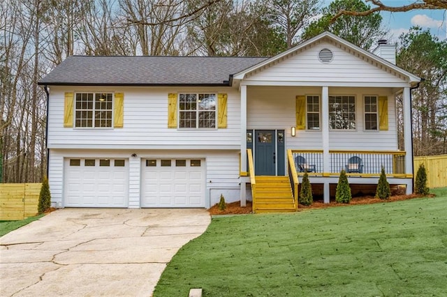 raised ranch with a garage, a front lawn, and a porch