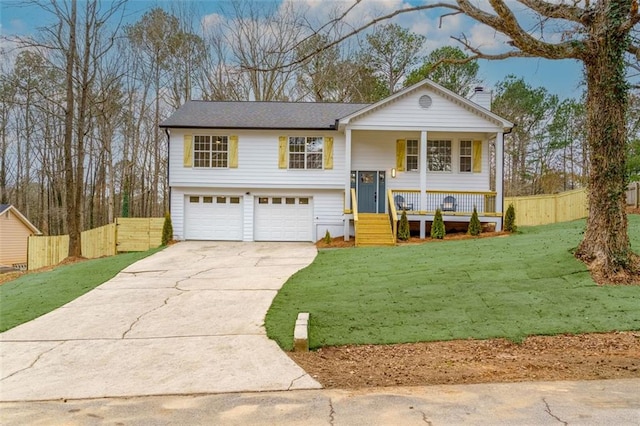 split foyer home with a garage, covered porch, and a front lawn