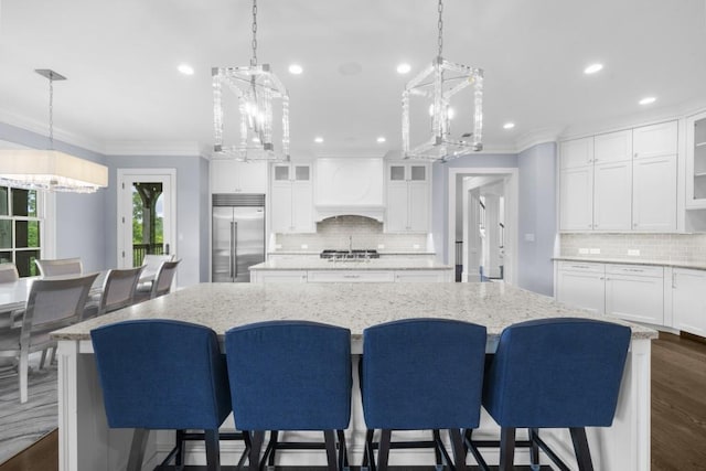 10150 Cedar Ridge Dr, Milton, GA 30004 - kitchen featuring stainless steel appliances, a chandelier, a kitchen island, crown molding, and premium range hood