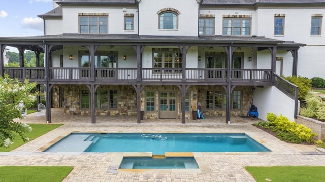 10150 Cedar Ridge Dr, Milton, GA 30004 - back of property featuring stone siding, an in-ground hot tub, and a patio