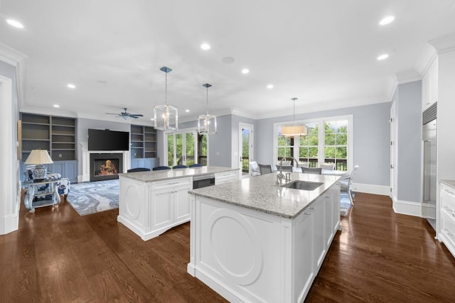 10150 Cedar Ridge Dr, Milton, GA 30004 - kitchen featuring a kitchen island with sink, ceiling fan, crown molding, recessed lighting, and a warm lit fireplace