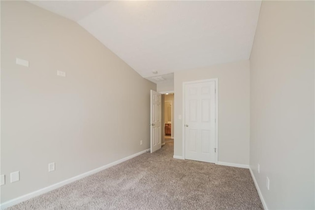 unfurnished bedroom featuring lofted ceiling, carpet, and baseboards