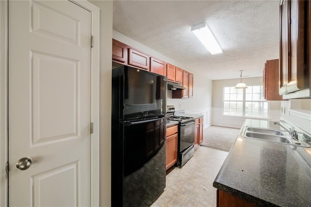 kitchen featuring wainscoting, dark countertops, under cabinet range hood, black appliances, and a sink