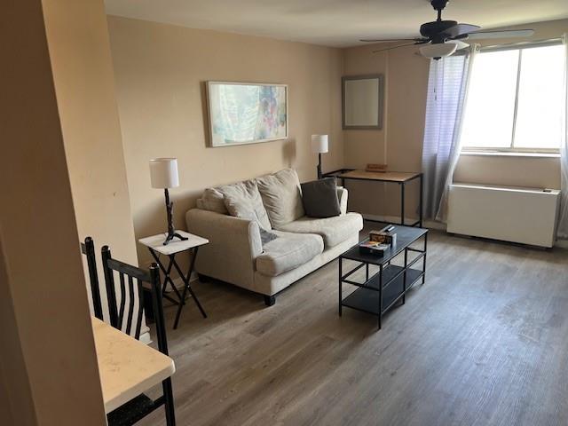 living room with wood-type flooring and ceiling fan