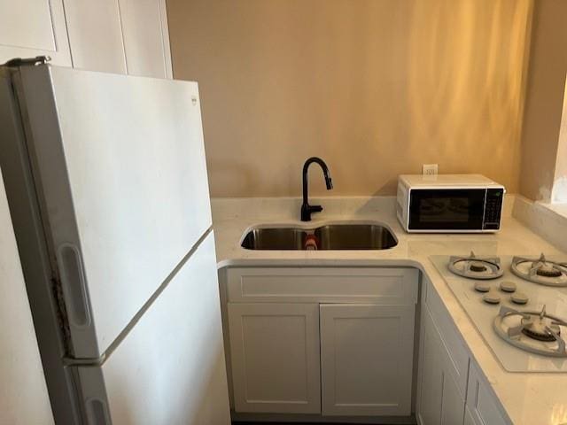 kitchen featuring white appliances and sink