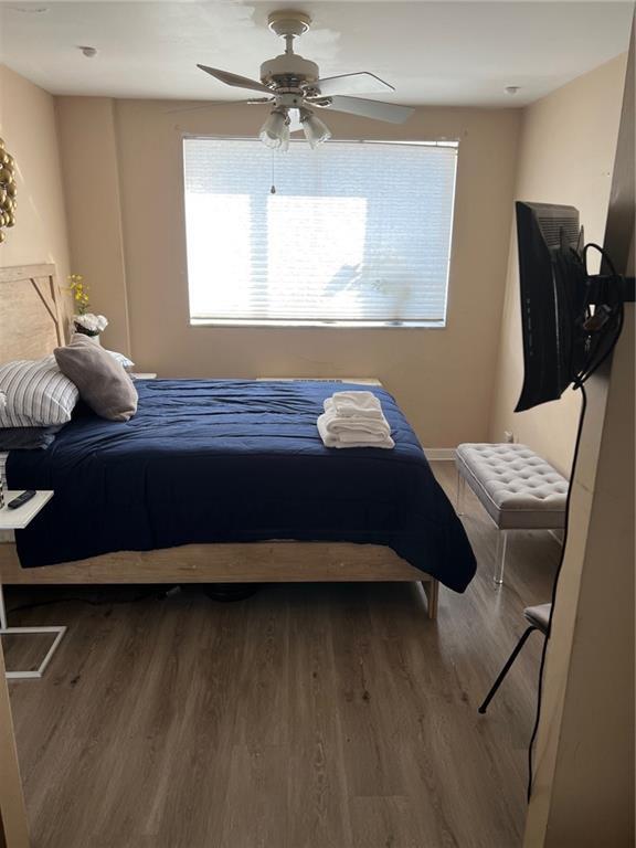 bedroom with hardwood / wood-style floors and ceiling fan