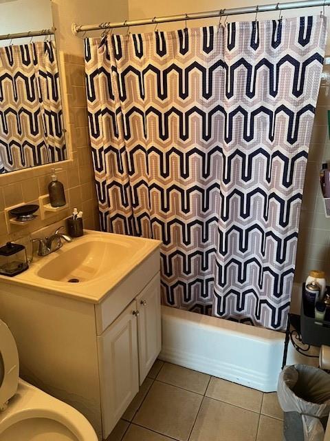 full bathroom featuring shower / bath combination with curtain, tile patterned floors, toilet, and vanity