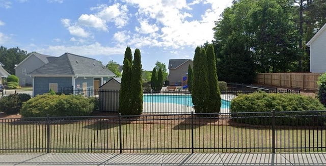 view of swimming pool featuring a yard