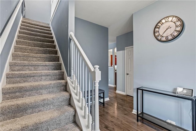 stairway with wood finished floors and baseboards