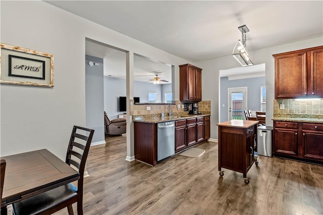 kitchen with dishwasher, tasteful backsplash, wood finished floors, and a sink