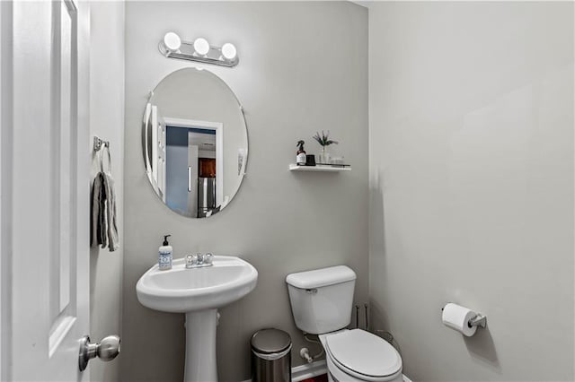 half bathroom featuring toilet and a sink