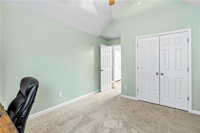 unfurnished office featuring vaulted ceiling, carpet floors, baseboards, and ceiling fan