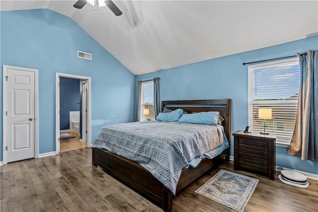 bedroom with lofted ceiling, wood finished floors, ceiling fan, ensuite bathroom, and baseboards