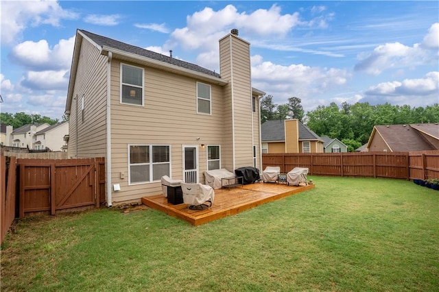 rear view of house featuring a chimney, a deck, and a gate