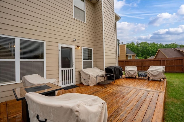 wooden terrace with a grill and fence