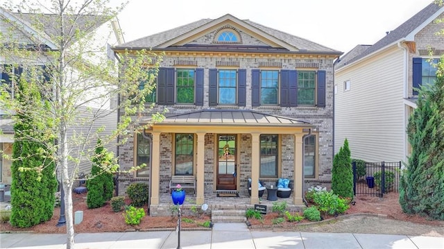 property entrance with brick siding, fence, and covered porch