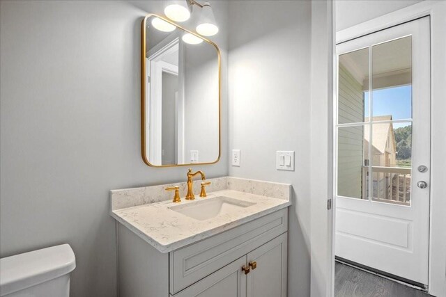 unfurnished bedroom with dark wood-type flooring, multiple windows, and ensuite bath