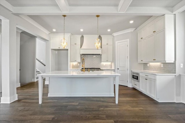 kitchen with dark wood-style floors, custom exhaust hood, stainless steel microwave, and beamed ceiling