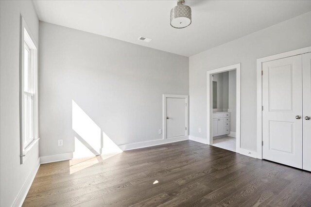 unfurnished room featuring a wealth of natural light and dark wood-type flooring