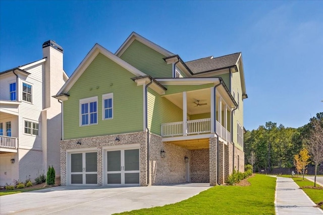 back of house with ceiling fan, a garage, and a balcony