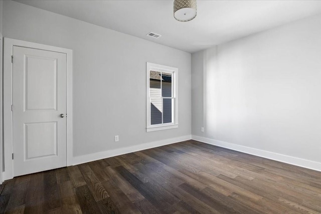 empty room with dark hardwood / wood-style flooring