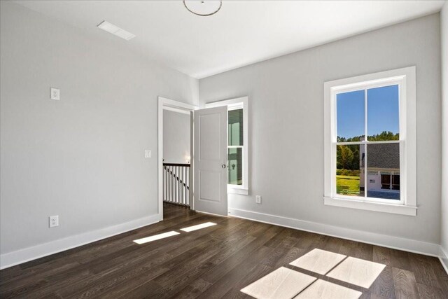 unfurnished room with dark wood-type flooring