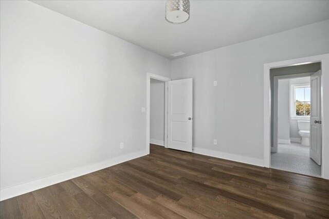 unfurnished bedroom with dark hardwood / wood-style flooring and a closet