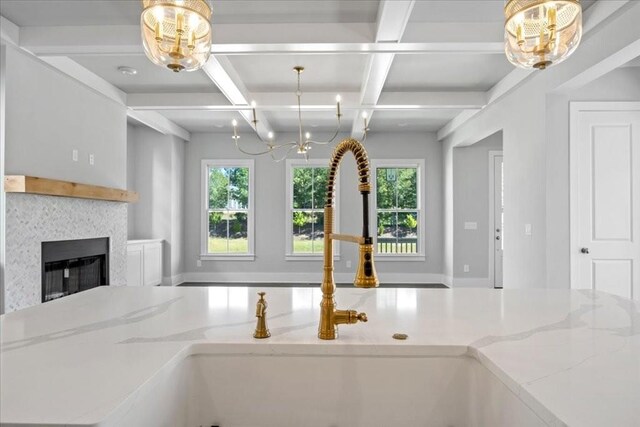 kitchen with light stone countertops, a fireplace, and hanging light fixtures