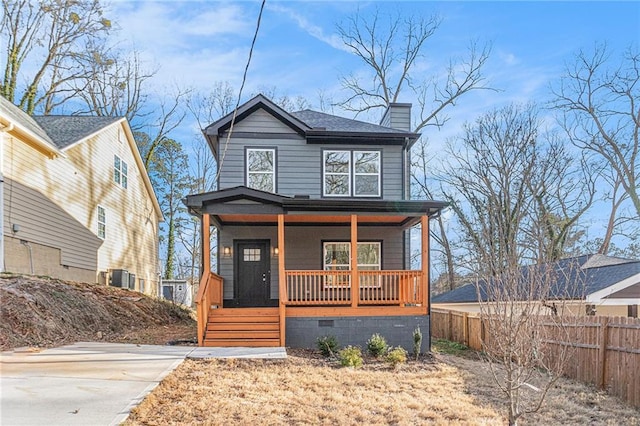 view of front of home with covered porch, fence, roof with shingles, crawl space, and a chimney