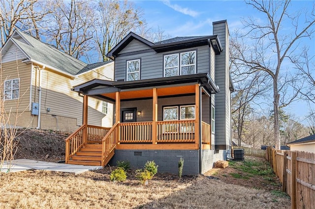 view of front of house with a porch, fence, a chimney, and central air condition unit