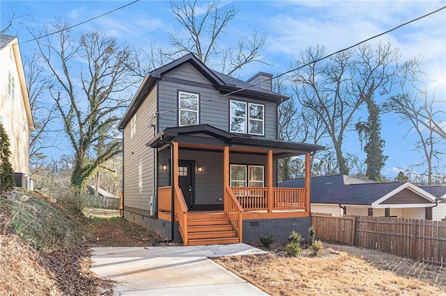 view of front of home with a porch, crawl space, and fence