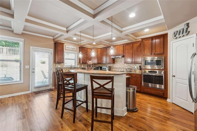 1249 Austin Thomas Dr, Dacula, GA 30019 - kitchen featuring coffered ceiling, appliances with stainless steel finishes, wood finished floors, and a kitchen bar