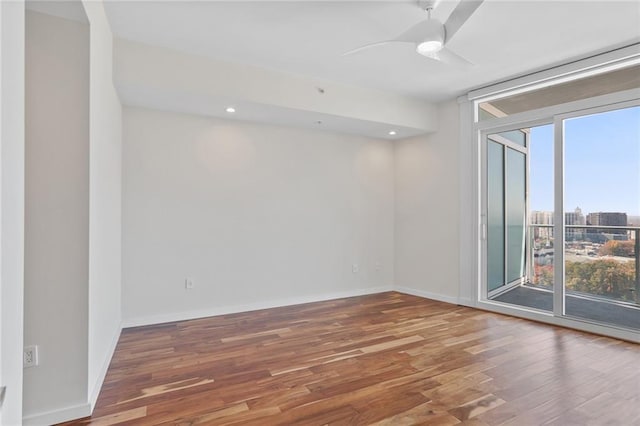 spare room featuring a wealth of natural light, hardwood / wood-style floors, and ceiling fan