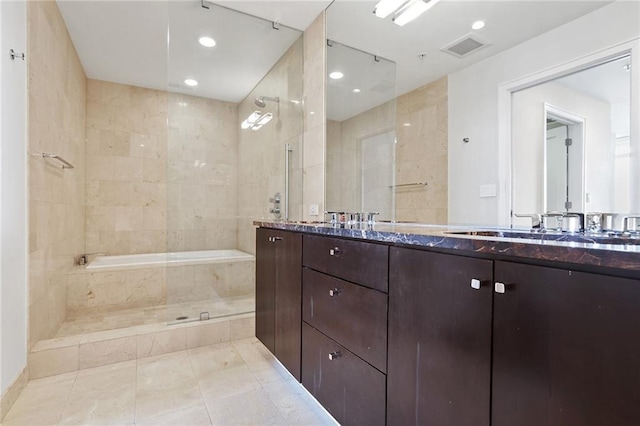 bathroom featuring plus walk in shower, vanity, and tile patterned flooring