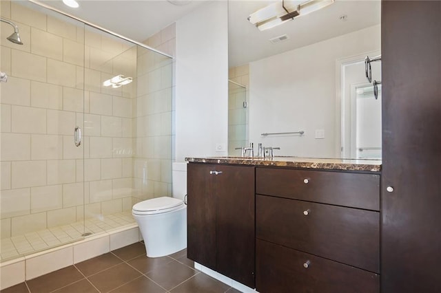 bathroom featuring tile patterned floors, vanity, toilet, and walk in shower