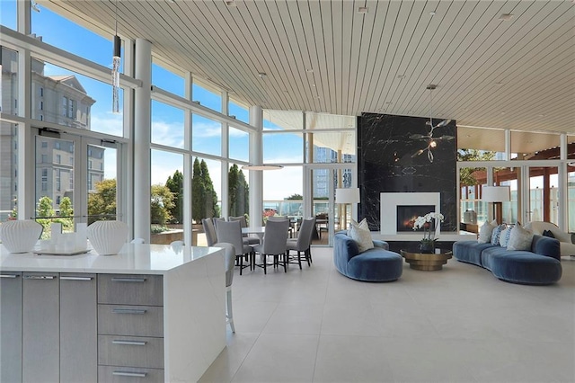 unfurnished sunroom with wood ceiling, a fireplace, and a healthy amount of sunlight